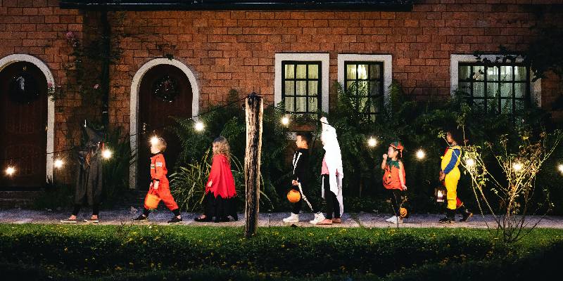 De jeunes enfants habillés en costumes d'Halloween font du porte-à-porte à la recherche de friandises